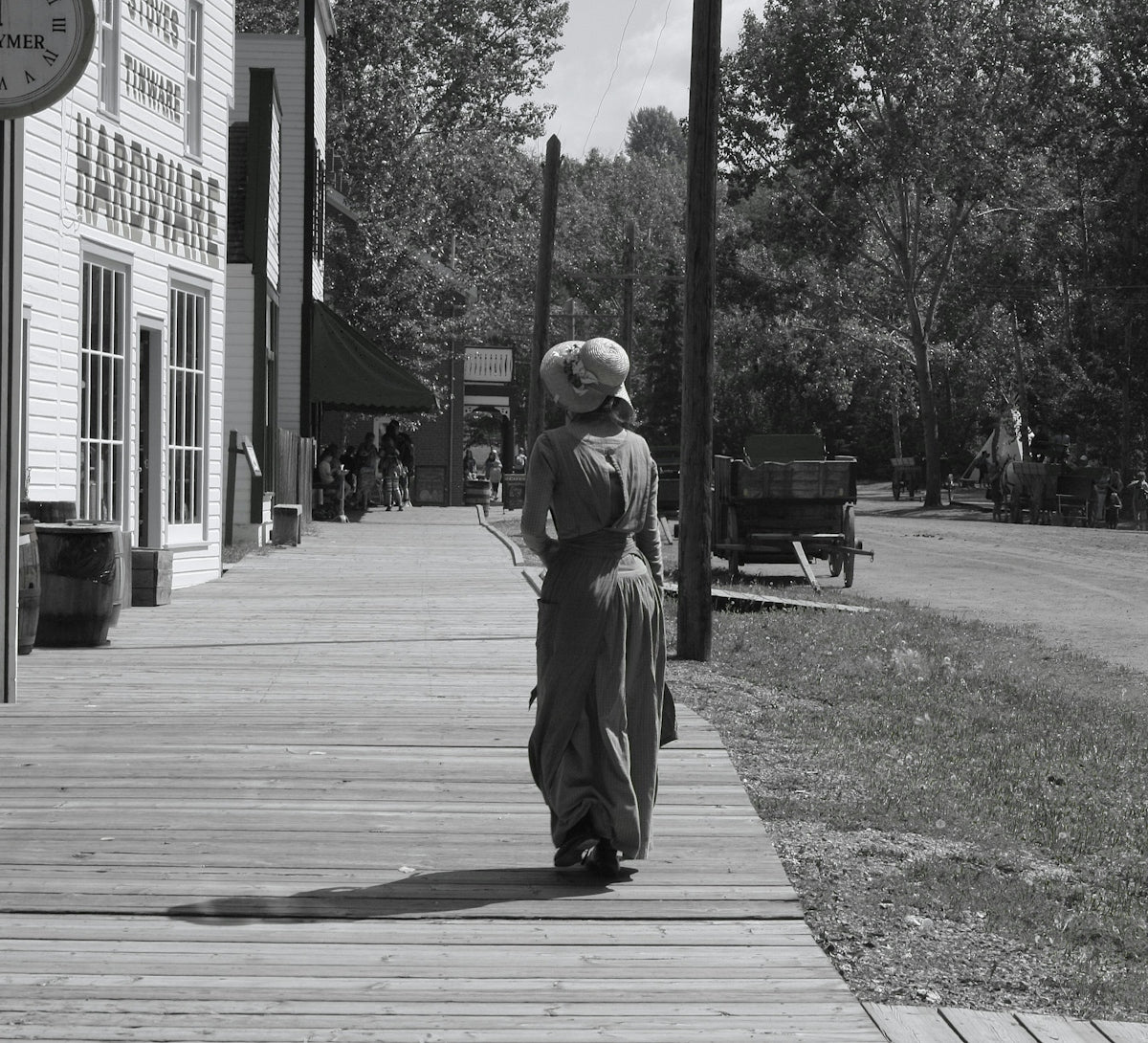 Woman in period dress walks on wooden boardwalk